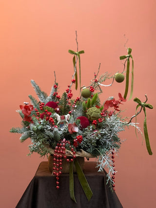 Christmas arrangement in natural wrap with red and green ornament