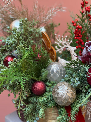 Christmas arrangement in gold vase with red and gold ornament
