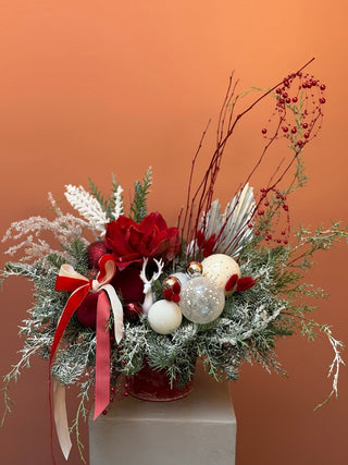 Christmas arrangement in red bucket with white and red ornament