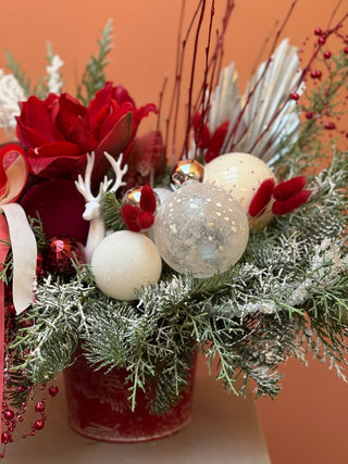 Christmas arrangement in red bucket with white and red ornament